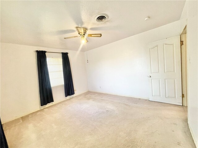 spare room featuring light carpet and ceiling fan