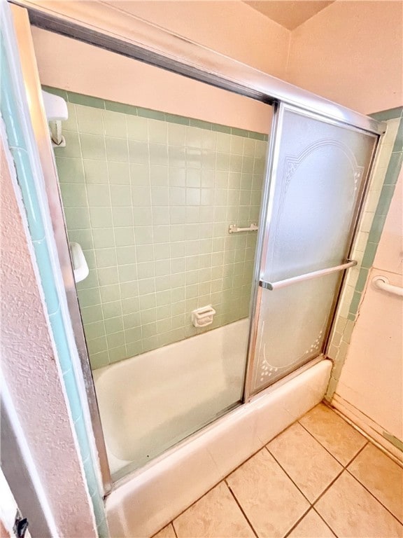 bathroom featuring bath / shower combo with glass door and tile patterned floors