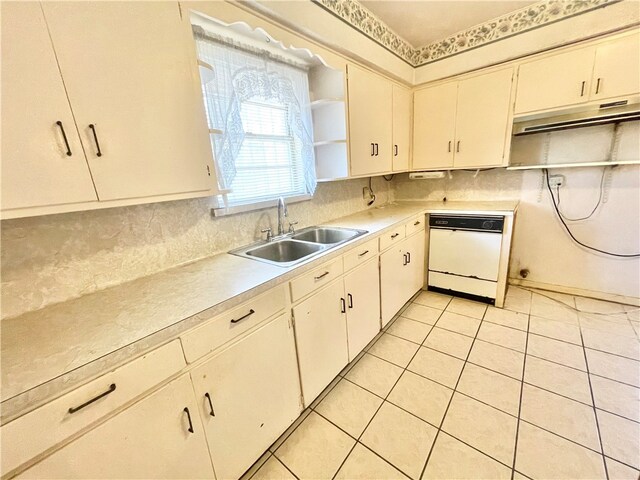 kitchen with decorative backsplash, sink, white dishwasher, and light tile patterned floors