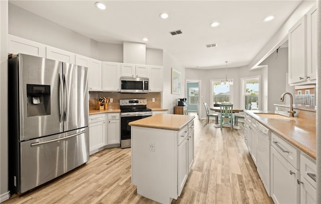 15822 Portillo Dr, Corpus Christi, TX 78418 - kitchen featuring stainless steel appliances, white cabinetry, light wood-type flooring, and recessed lighting