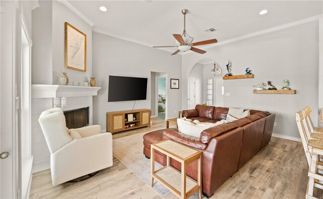 15822 Portillo Dr, Corpus Christi, TX 78418 - living area featuring light wood finished floors, arched walkways, ornamental molding, a fireplace, and ceiling fan