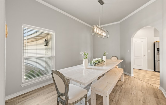 15822 Portillo Dr, Corpus Christi, TX 78418 - dining area with arched walkways, light wood-style flooring, crown molding, and plenty of natural light