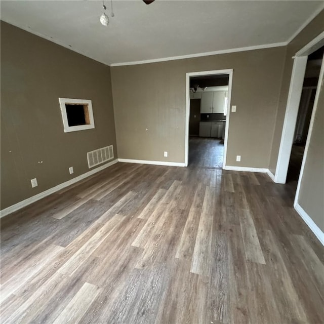 empty room featuring dark hardwood / wood-style flooring and crown molding