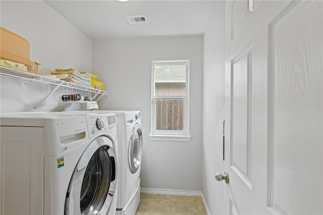 clothes washing area with light tile patterned flooring and washing machine and clothes dryer