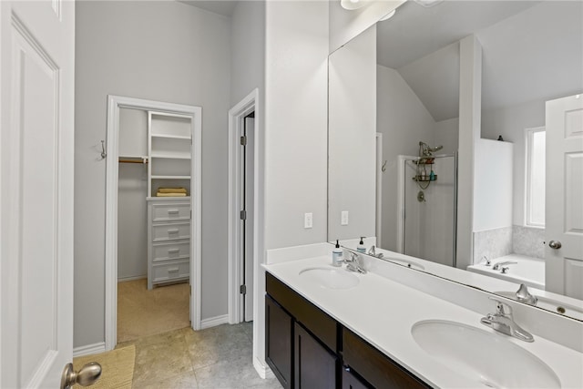 bathroom featuring tile patterned floors, a washtub, vanity, and lofted ceiling