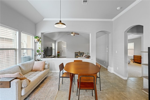 tiled dining room featuring ceiling fan, lofted ceiling, and ornamental molding