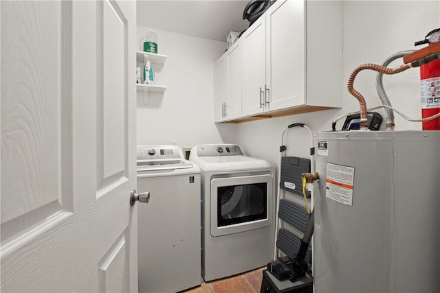 washroom featuring electric water heater, cabinets, and independent washer and dryer