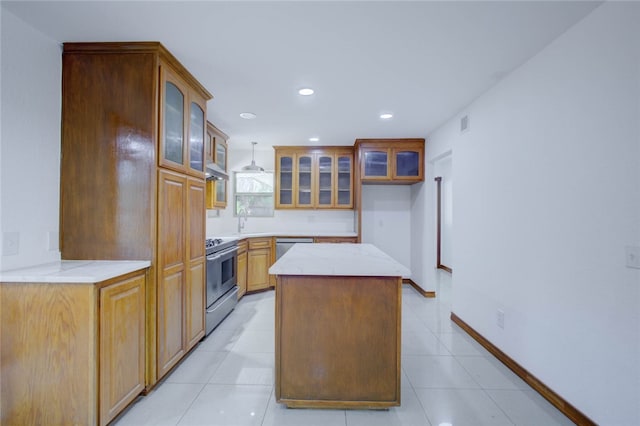 kitchen with a center island, sink, light tile patterned flooring, pendant lighting, and appliances with stainless steel finishes