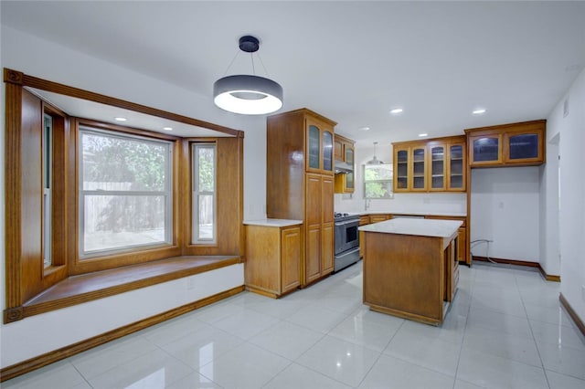 kitchen with light tile patterned flooring, extractor fan, stainless steel range with electric stovetop, hanging light fixtures, and a kitchen island