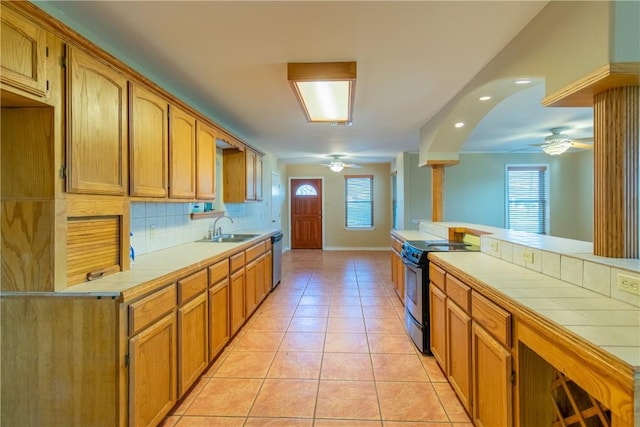 kitchen with tile countertops, a wealth of natural light, black electric range, and sink