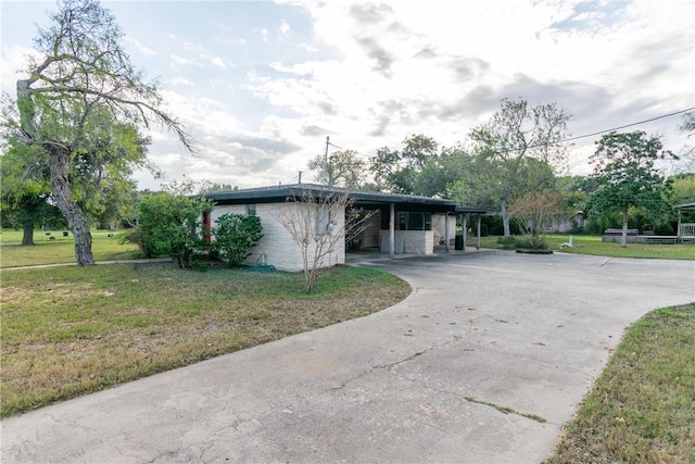 view of side of home featuring a yard and a carport