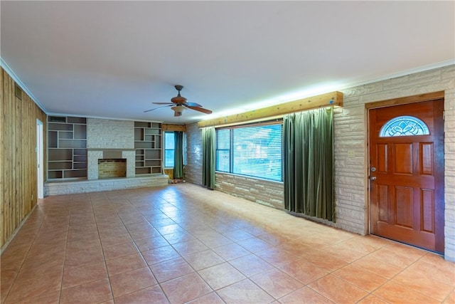 unfurnished living room featuring a stone fireplace, ceiling fan, and light tile patterned flooring