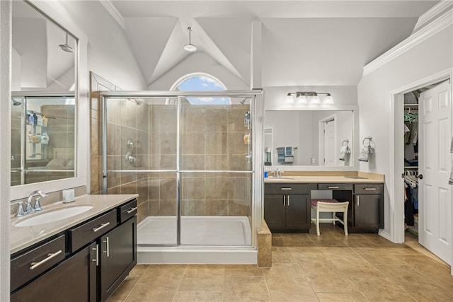 7502 Stampede Dr, Corpus Christi, TX 78414 - full bathroom with two vanities, a stall shower, a spacious closet, lofted ceiling, and tile patterned floors