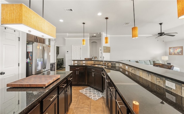 7502 Stampede Dr, Corpus Christi, TX 78414 - kitchen with stainless steel fridge, washer and dryer, a ceiling fan, dark stone countertops, and pendant lighting
