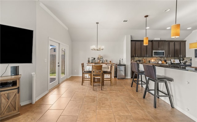 7502 Stampede Dr, Corpus Christi, TX 78414 - kitchen with stainless steel microwave, dark countertops, dark brown cabinets, tasteful backsplash, and a kitchen bar