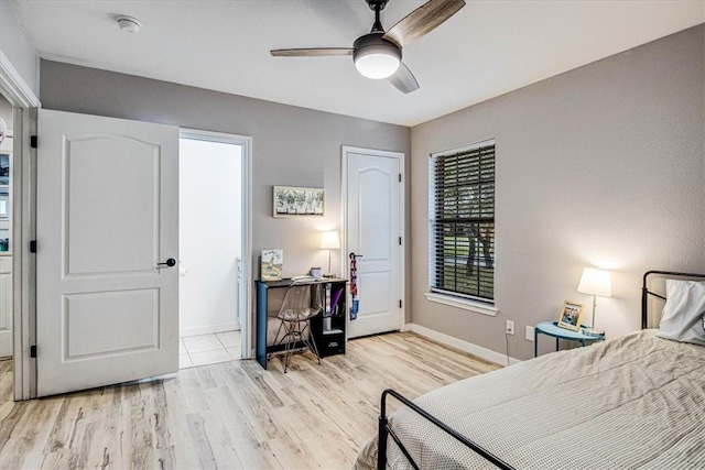 bedroom featuring light wood-type flooring, a ceiling fan, and baseboards