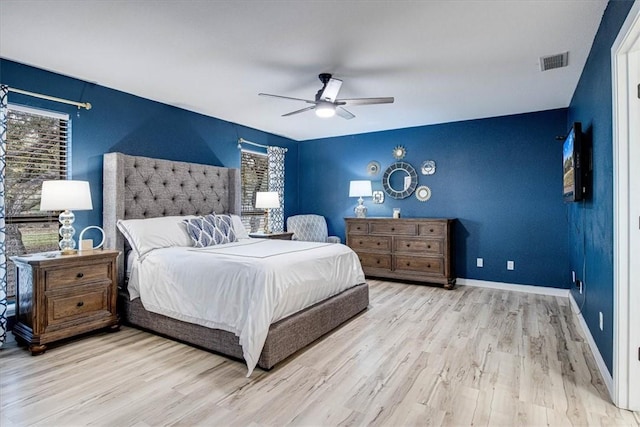 bedroom with light wood-type flooring, baseboards, visible vents, and a ceiling fan