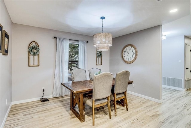 dining room with light wood-style flooring, visible vents, and baseboards