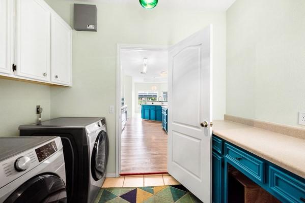 14154 Cutlass Ave, Corpus Christi, TX 78418 - washroom featuring cabinet space, separate washer and dryer, and light tile patterned flooring