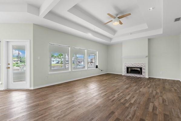 14154 Cutlass Ave, Corpus Christi, TX 78418 - unfurnished living room featuring a raised ceiling, healthy amount of natural light, dark wood-style flooring, and a ceiling fan