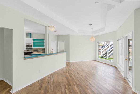 14154 Cutlass Ave, Corpus Christi, TX 78418 - unfurnished living room featuring wood finished floors and a raised ceiling