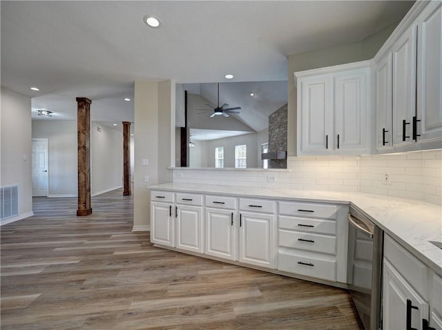 kitchen featuring backsplash, white cabinetry, and lofted ceiling