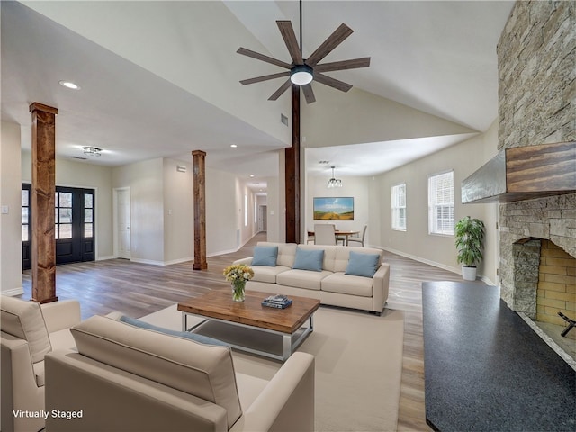 living room with ceiling fan, a healthy amount of sunlight, light wood-type flooring, and lofted ceiling