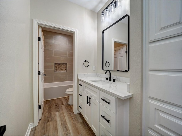 full bathroom with toilet, vanity, tiled shower / bath combo, and hardwood / wood-style flooring