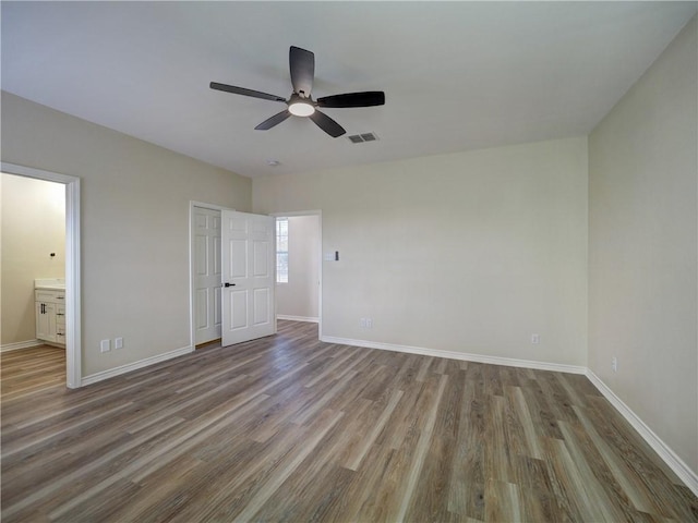 unfurnished bedroom with ceiling fan, hardwood / wood-style floors, and ensuite bathroom