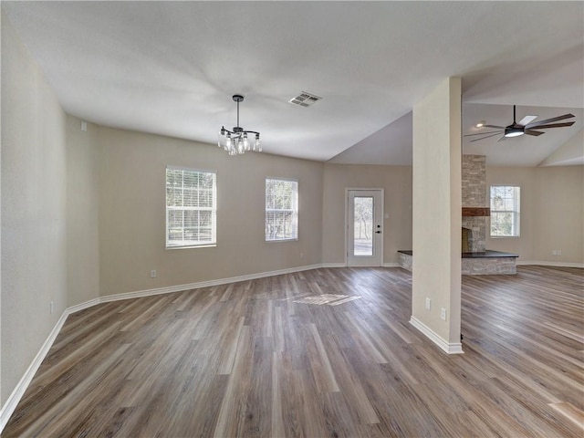 unfurnished living room featuring a fireplace, hardwood / wood-style floors, ceiling fan with notable chandelier, and vaulted ceiling