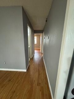 hallway with baseboards and wood finished floors