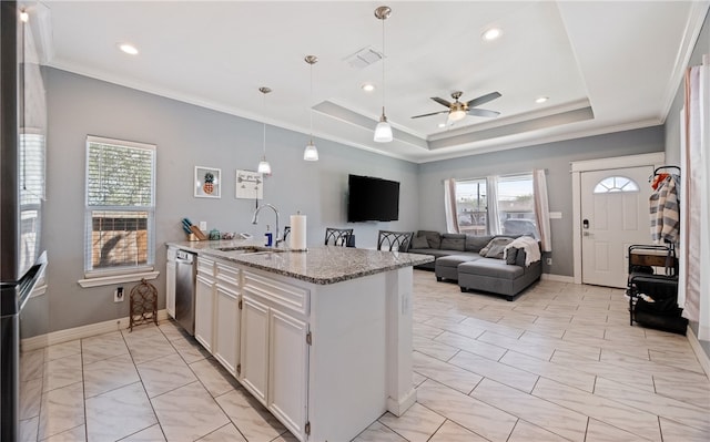 kitchen featuring ornamental molding, a raised ceiling, a sink, and light stone countertops