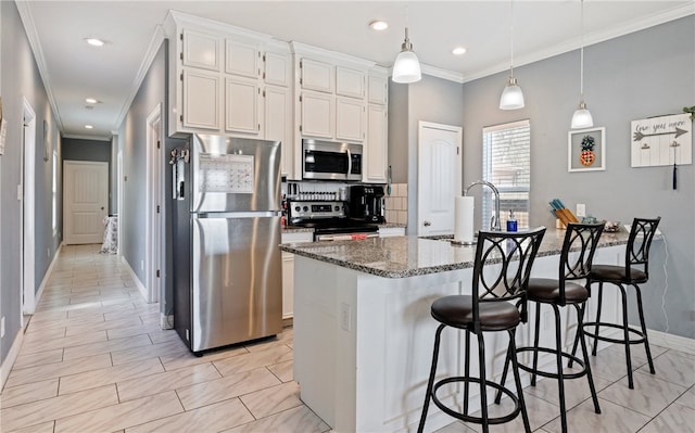 kitchen with a breakfast bar, tasteful backsplash, appliances with stainless steel finishes, white cabinetry, and dark stone countertops