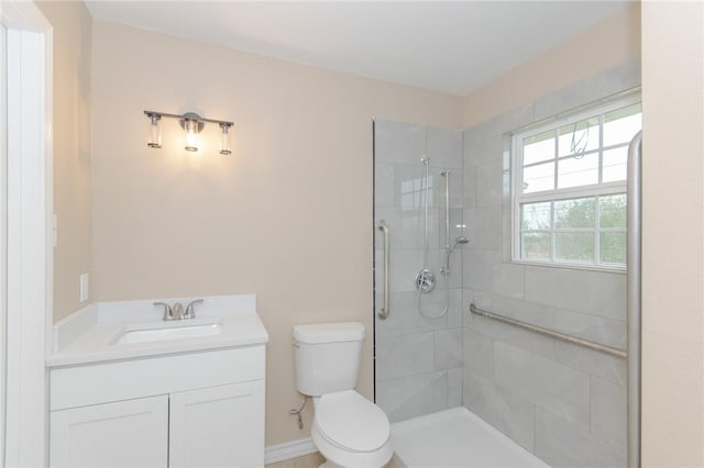 bathroom with toilet, vanity, and a tile shower