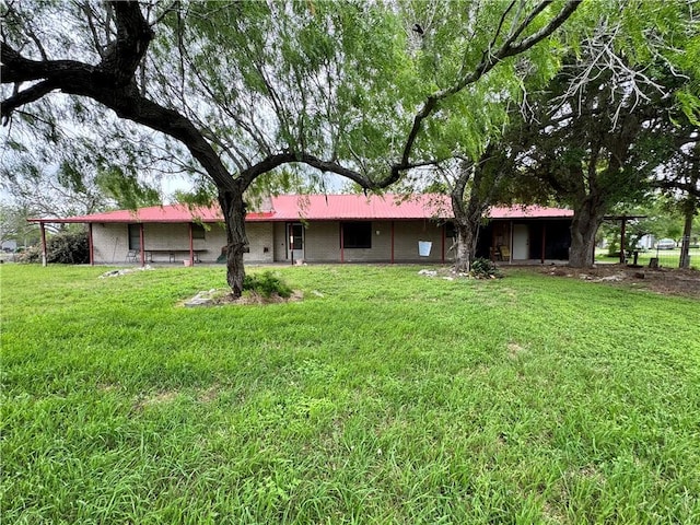 back of house with a lawn and metal roof