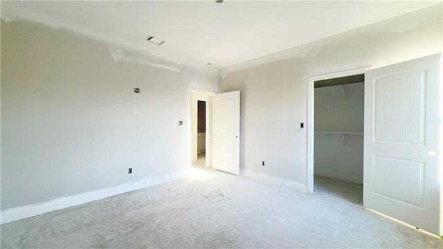 unfurnished bedroom featuring baseboards, a closet, and concrete flooring