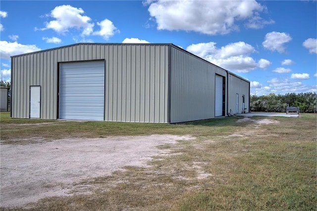 view of outbuilding with a garage and a lawn