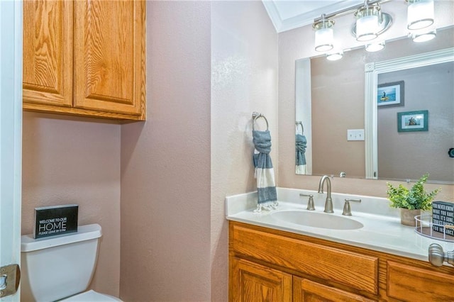 bathroom featuring vanity, ornamental molding, and toilet