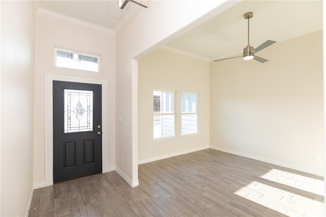 foyer with light wood-type flooring, ceiling fan, and ornamental molding