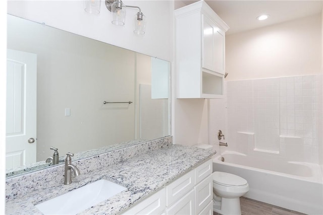 full bathroom featuring vanity, hardwood / wood-style flooring, toilet, and tub / shower combination