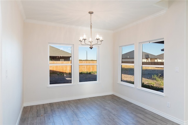 unfurnished dining area featuring crown molding, hardwood / wood-style floors, and an inviting chandelier