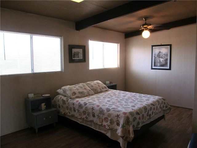 bedroom featuring ceiling fan, dark wood-type flooring, and beamed ceiling