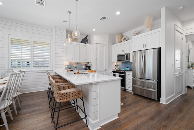 kitchen featuring white cabinets, appliances with stainless steel finishes, backsplash, and kitchen peninsula