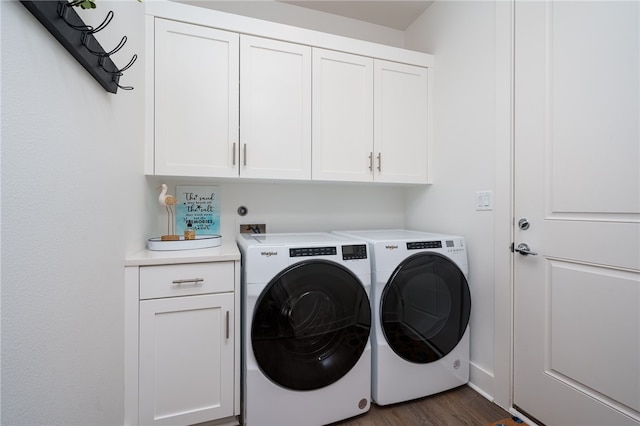 laundry room featuring cabinets, independent washer and dryer, and dark hardwood / wood-style floors