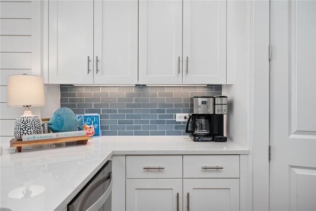 kitchen with white cabinetry, dishwasher, backsplash, and light stone counters