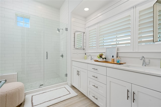 bathroom featuring an enclosed shower, vanity, a wealth of natural light, and hardwood / wood-style flooring