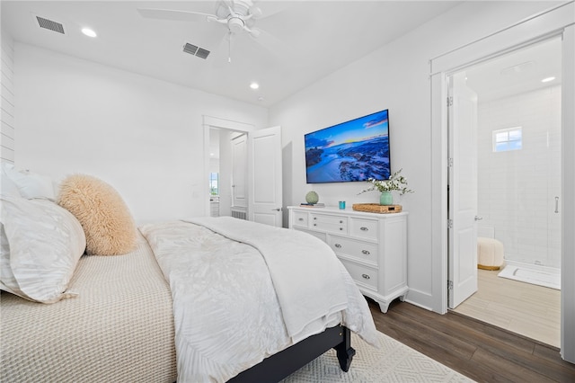 bedroom with dark wood-type flooring, ceiling fan, connected bathroom, and multiple windows