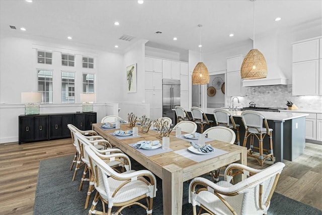 dining room with light wood-type flooring, visible vents, and recessed lighting