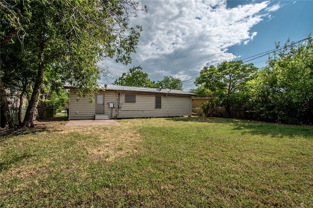 back of house with a patio area and a lawn