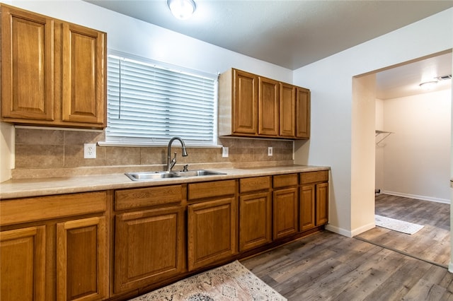 kitchen with dark wood-type flooring, sink, and tasteful backsplash